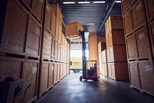 Freys magasin med specialbyggda trälådor för förvaring av dina möbler och tillhörigheter och en truck med Freys förare.